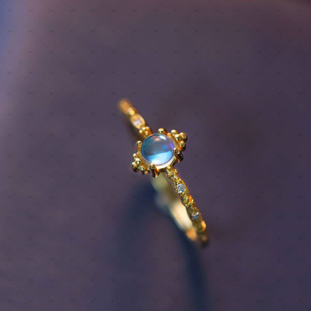 Gold ring with a blue gemstone on a dark textured background
